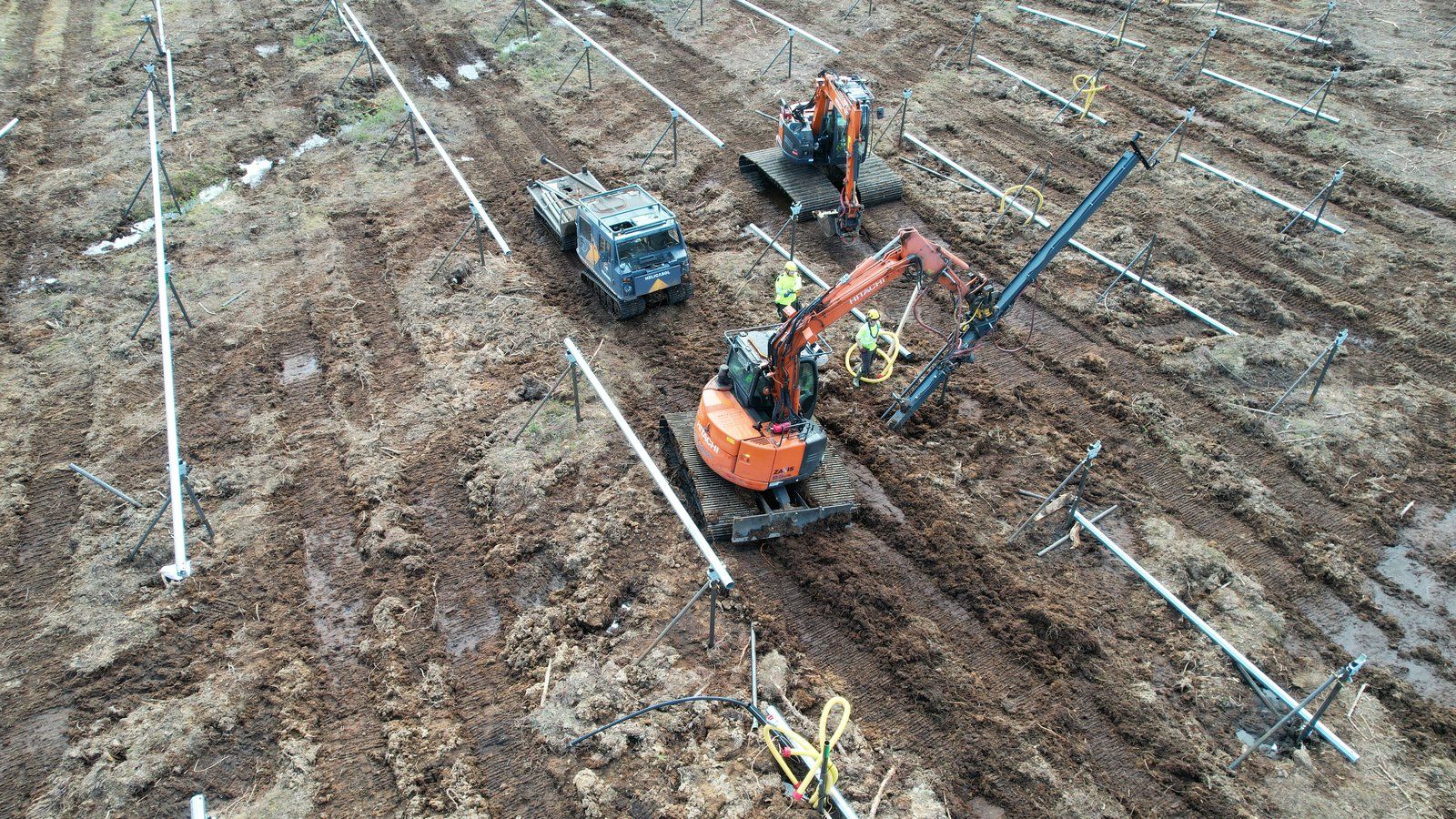 Aerial view of Helicasol crew installing piles in formation across a solar site