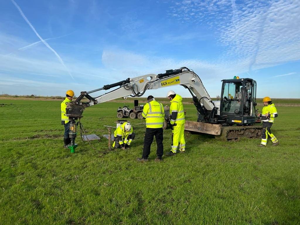 Helicasol field testing crew on site in England — pile installation with multiple engineers